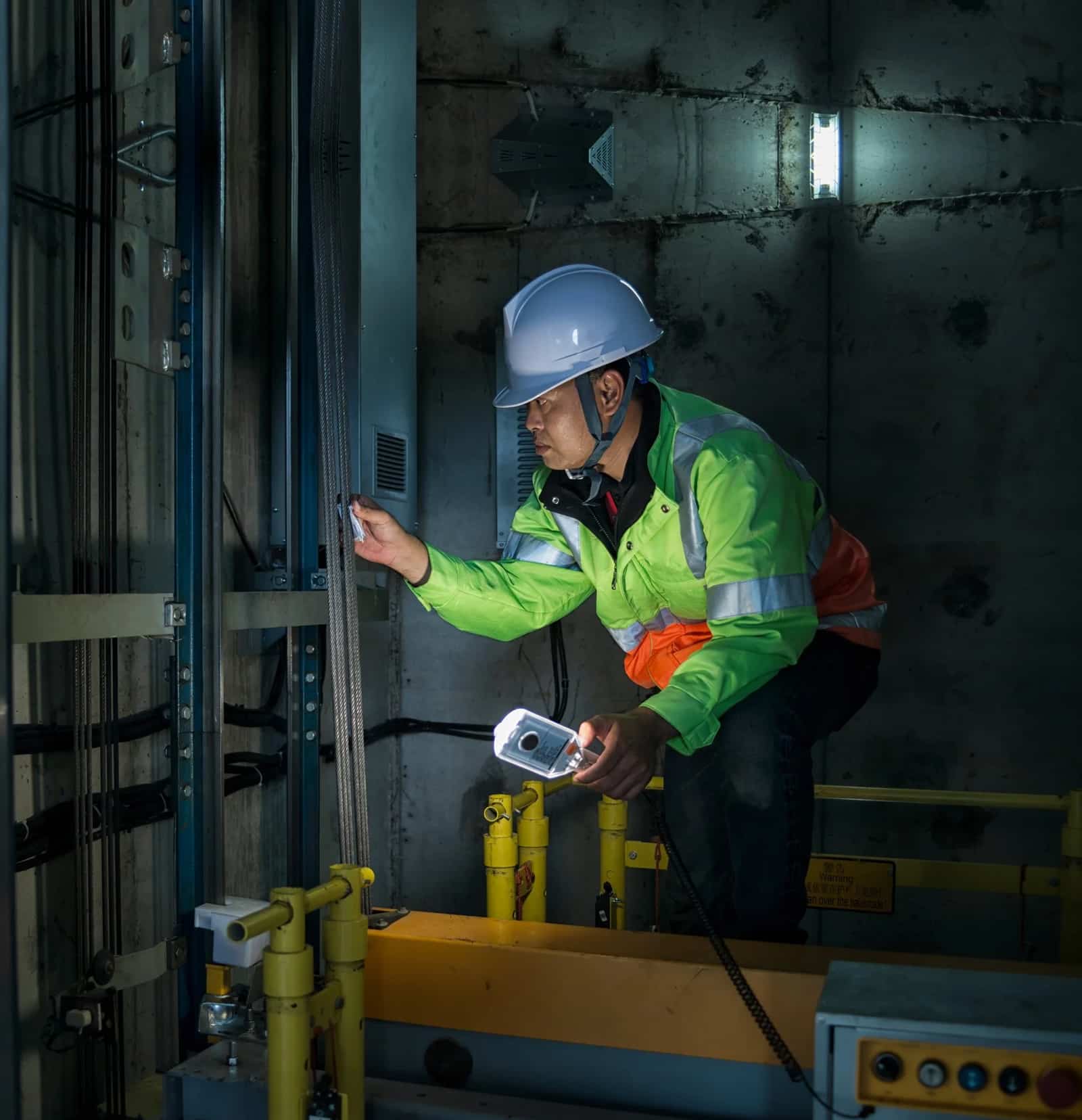 Elevator maintenance technician servicing a hoistway in Miami, FL